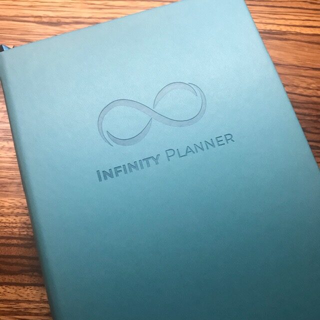 Blue planner with infinity planner and symbol on the front cover.