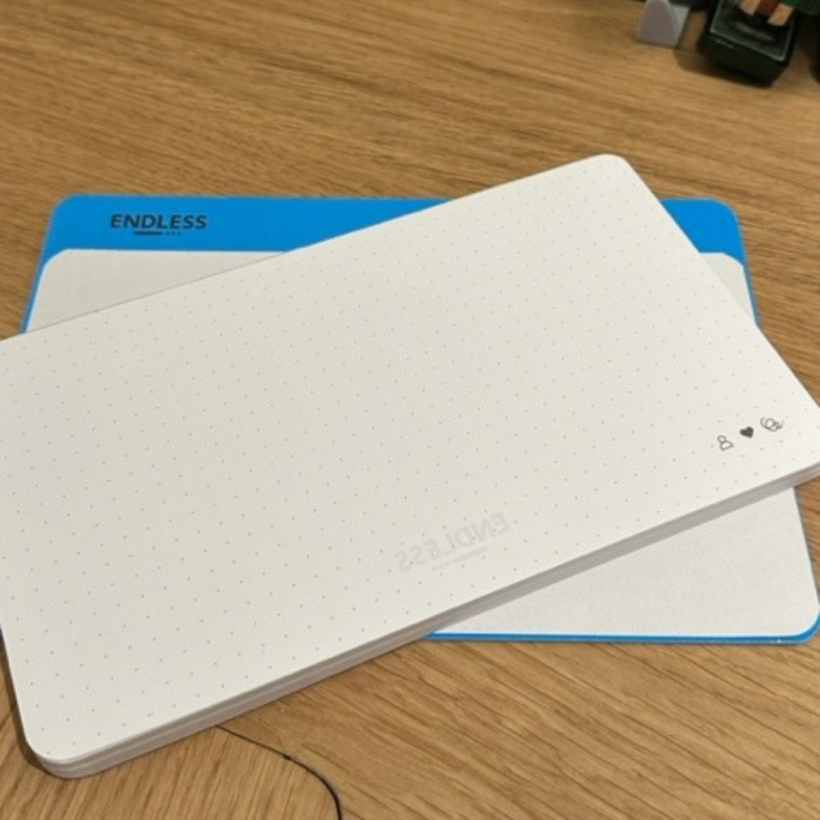 Notepad with dotted paper from made by endless on table sitting on blue backing card