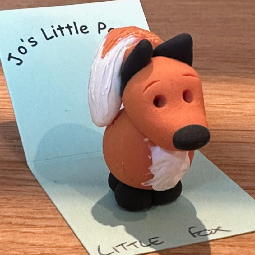 small clay polymer fox on backing card with the logo "jo's little people "on it in black.