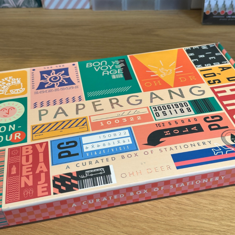 papergang box with bon voyage theme, the box has the word papergang in silver in the centre and is surrounded by travel ticket images