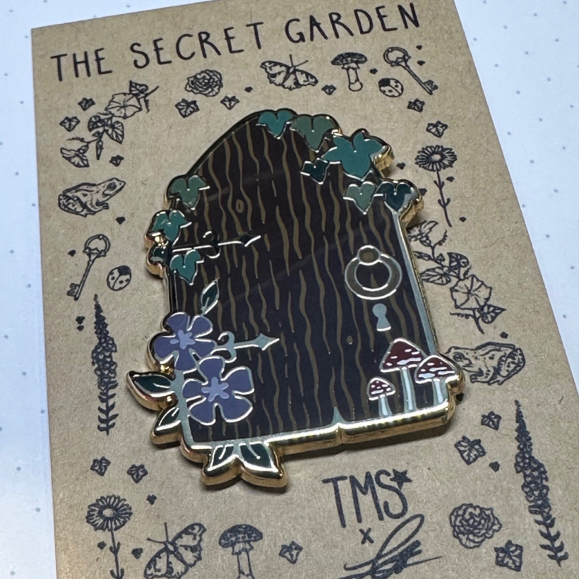 Secret door enamel pin on secret garden backing card.