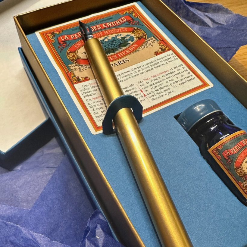 jacques herbin writing set open to show what is in the box which includes golden pen with nib and bottle of blue ink